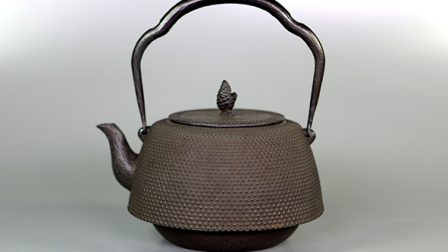 The iron teapot with dewdrop patterns on the surface.