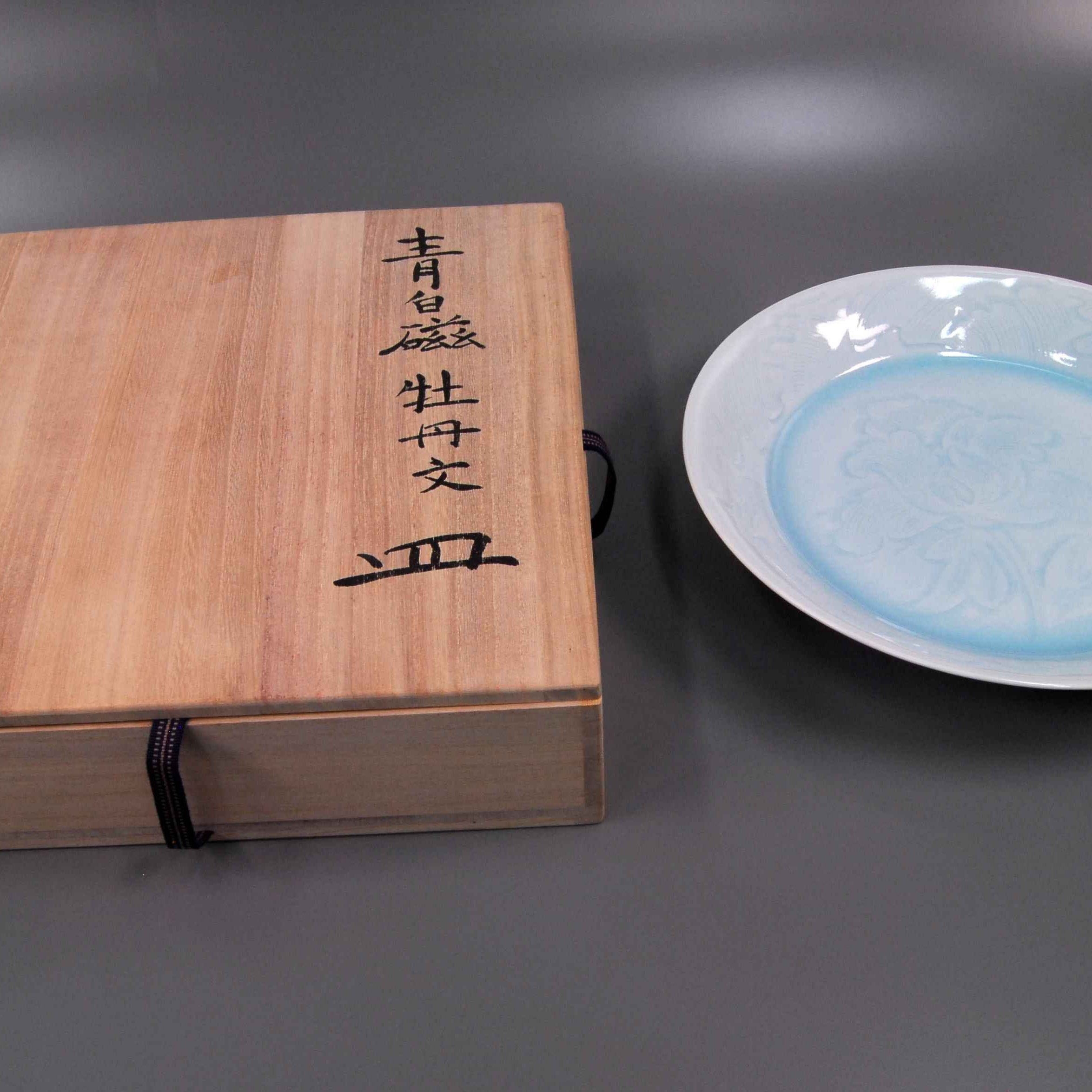 The porcelain plate and its special wooden case. The signature of the producer is on the surface of the box.