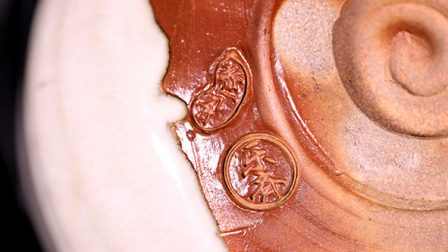 Close-up view of the producer’s name on the bottom of the bowl, the name of “Rakusai” written.